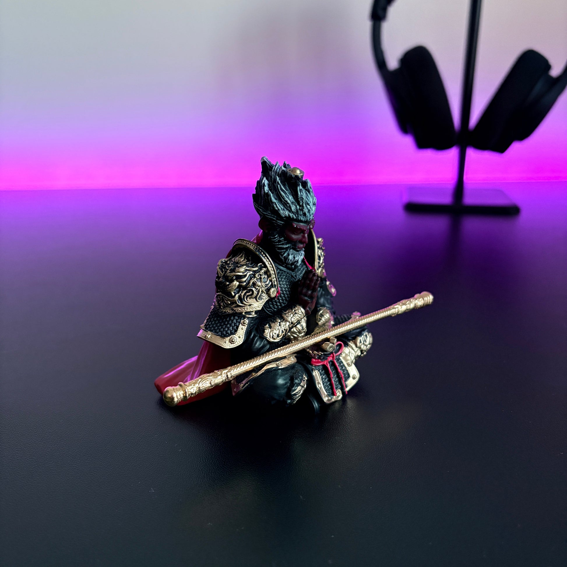 Small figurine of a warrior with a staff on a dark surface with a blurred background