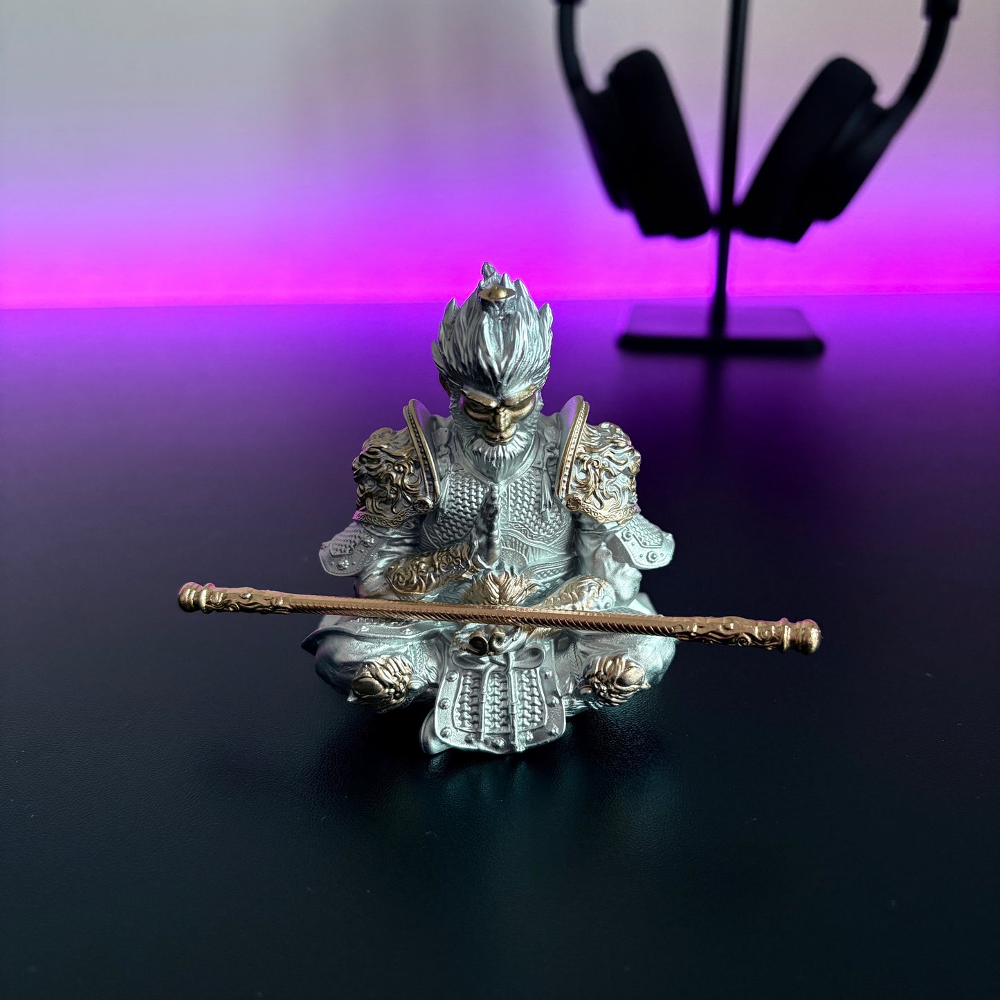 Silver warrior figurine with a spear on a reflective surface with a purple gradient background
